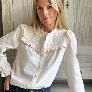 A true classic. Soft quilted yolk and coral ruffle trim and details