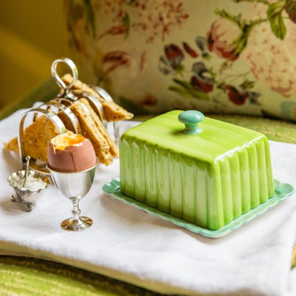 Boiled egg and toast on a tray with green butter dish