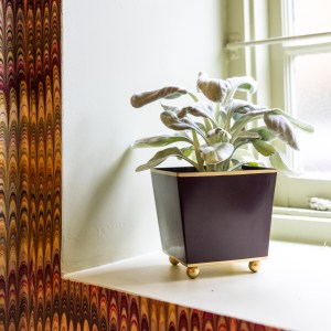 Purple planter against a marble wall paper background