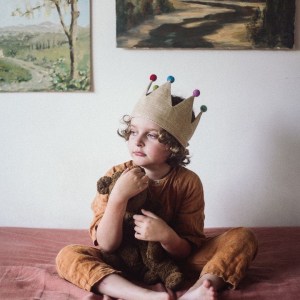 Little boy wearing gold linen crown