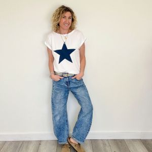 DA WEARING A WHITE TEE WITH BIG NAVY STAR ON THE FRONT AND BAGGY BARREL JEANS