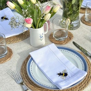 Summer tables cape showing Embroidered linen napkins, jugs, seagrass placemats